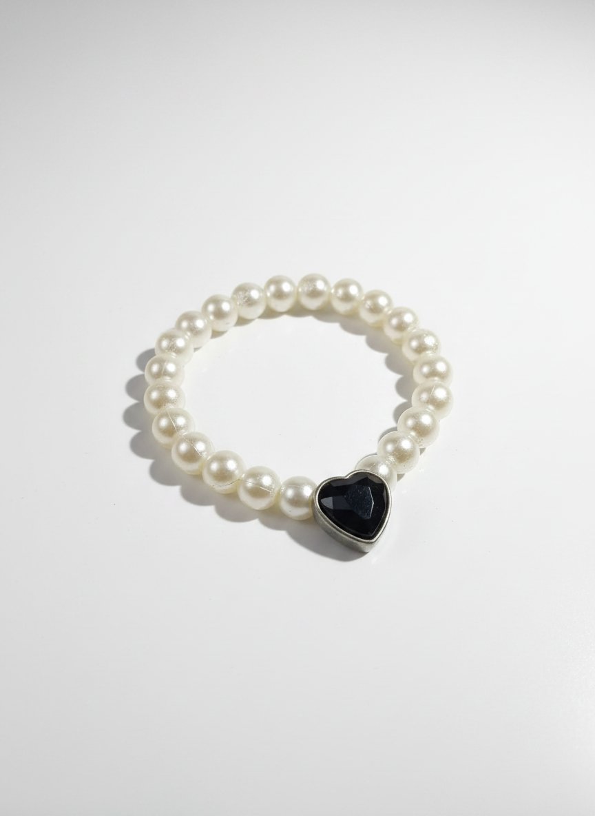 Un bracelet blanc orné d’un cœur noir en son centre