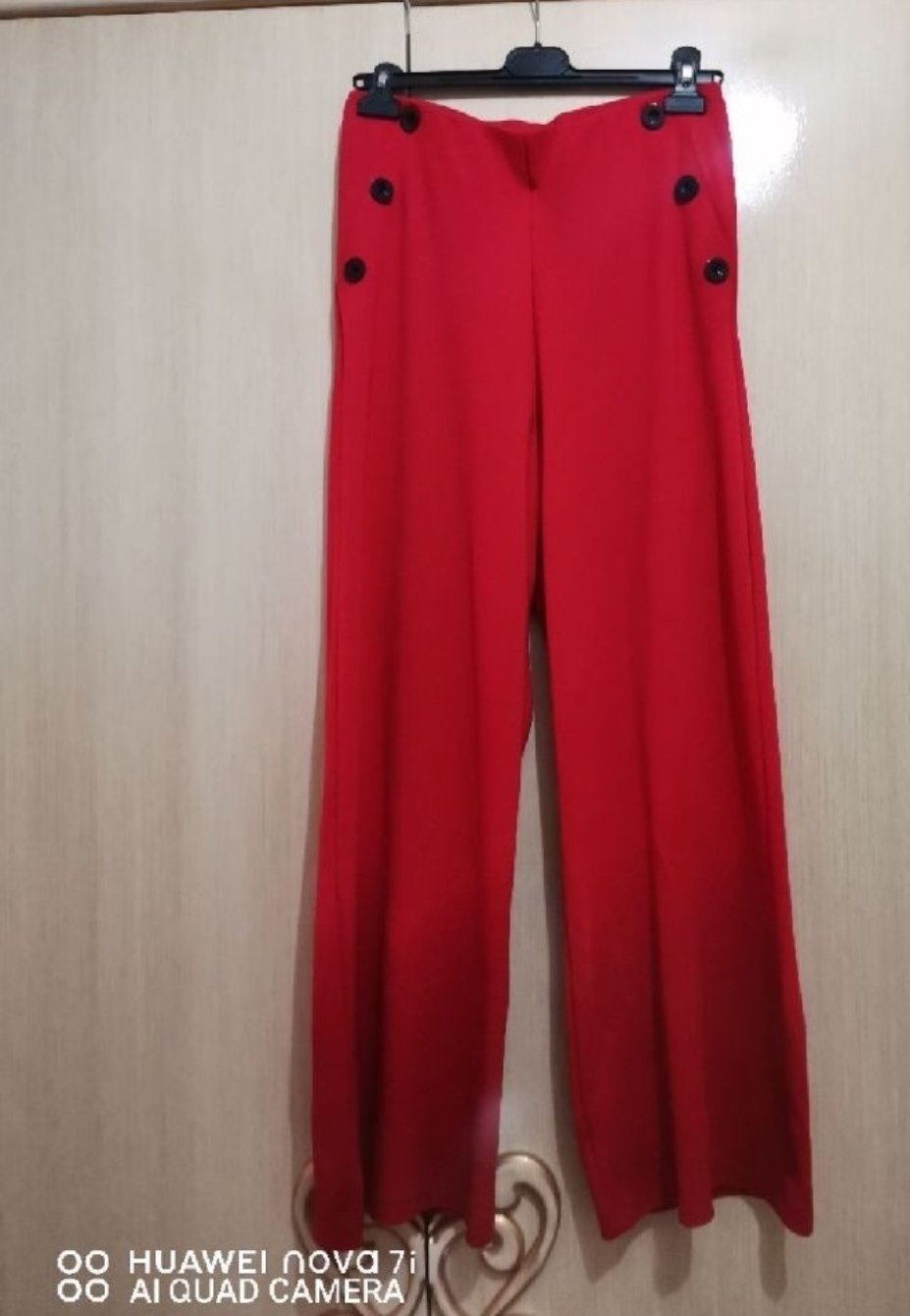 Pantalon large  busem, caractérisé par des détails de boutons latéraux à la taille  