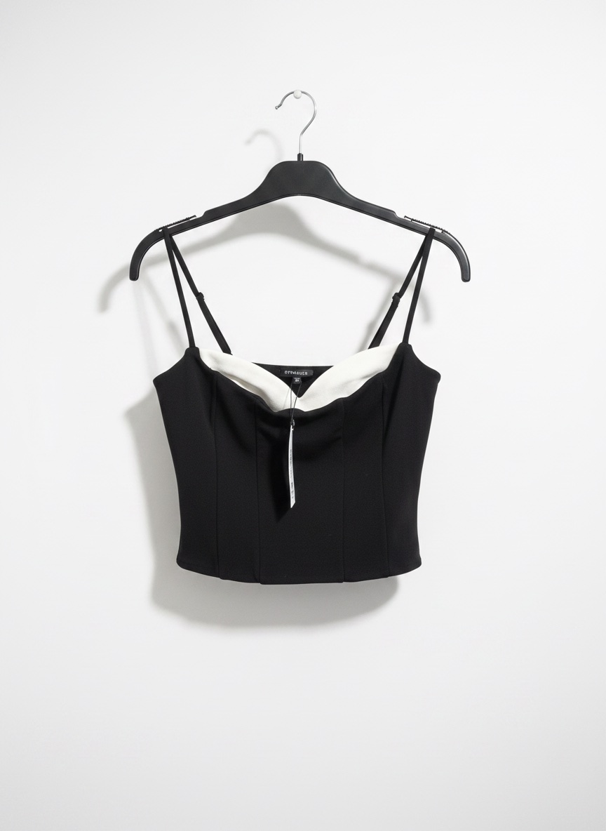 Ce haut est un corset noir de marque Dynamite avec un décolleté en cœur contrastant blanc et des bretelles ajustables