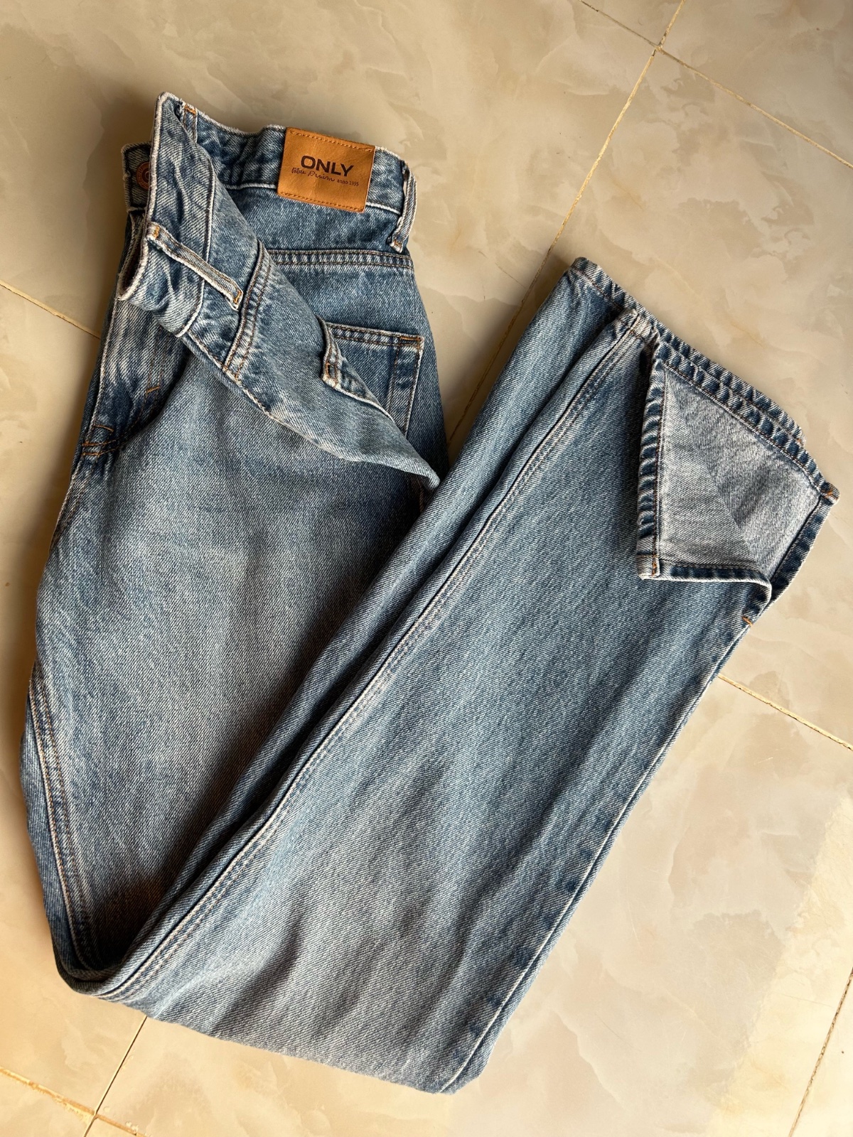 Ce jean de la marque ONLY arbore une coupe droite classique avec un délavage bleu clair.