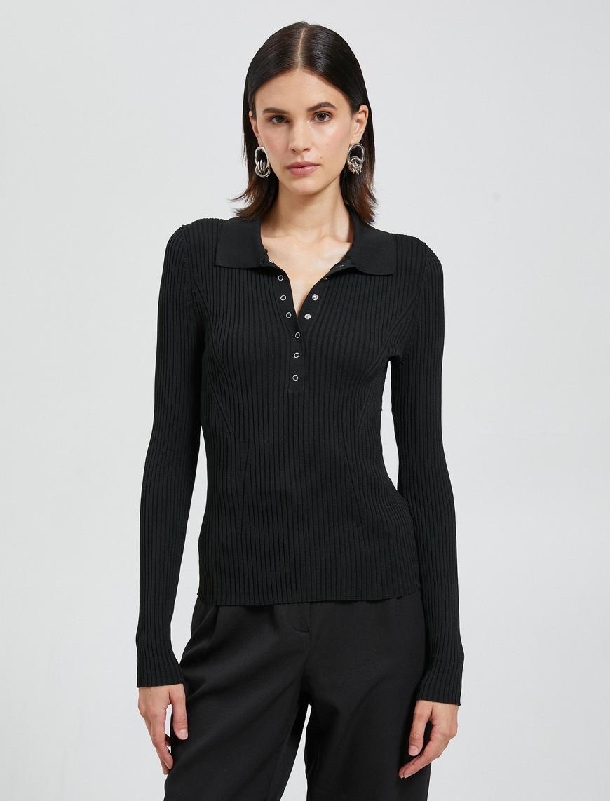 Ce pull-over noir à manches longues de la marque Zara est un haut côtelé ajusté doté d'un col polo et d'une patte de boutonnage à boutons-pression