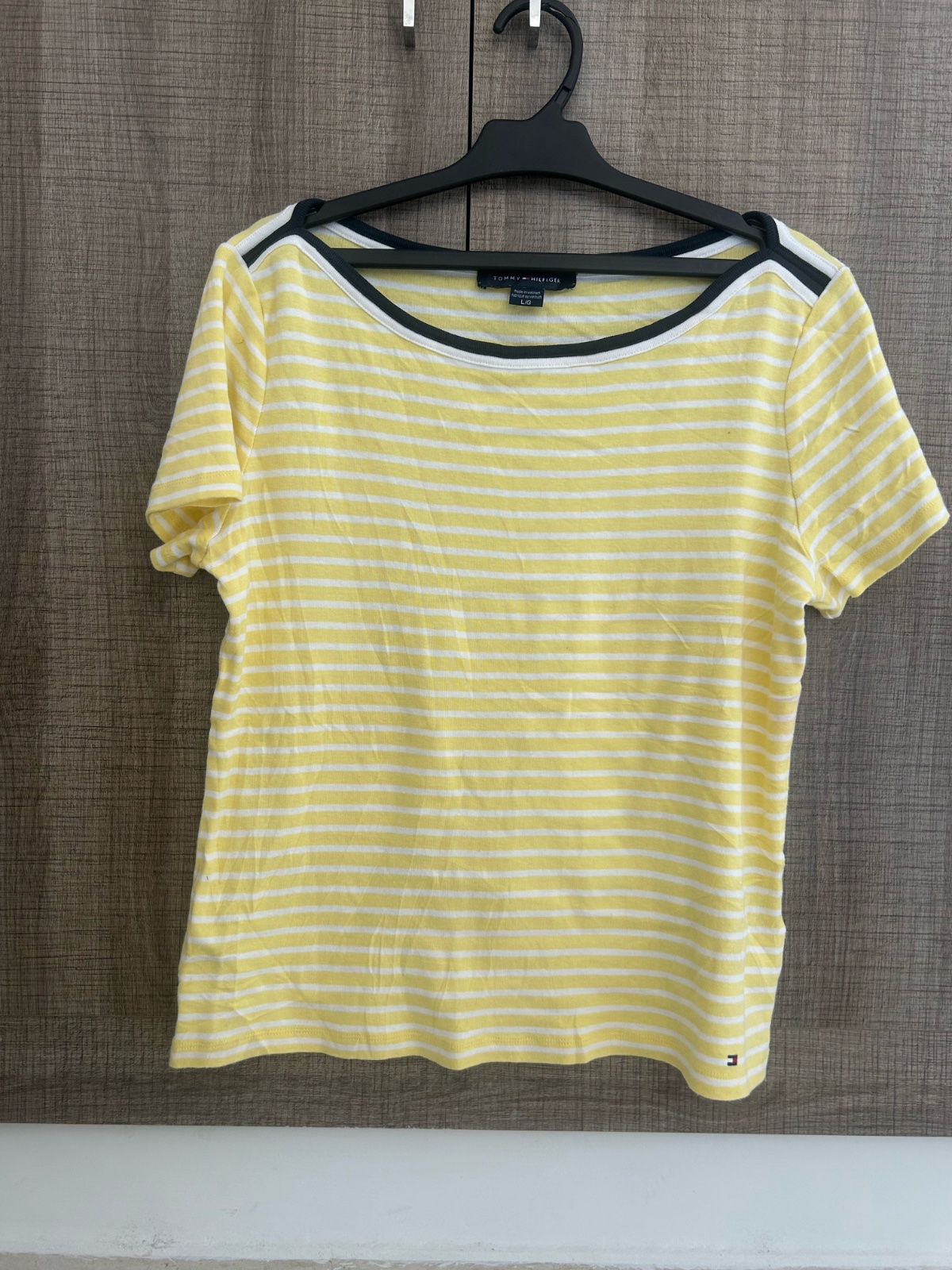 Ce haut rayé jaune et blanc de Tommy Hilfiger présente un col rond classique et des manches courtes.