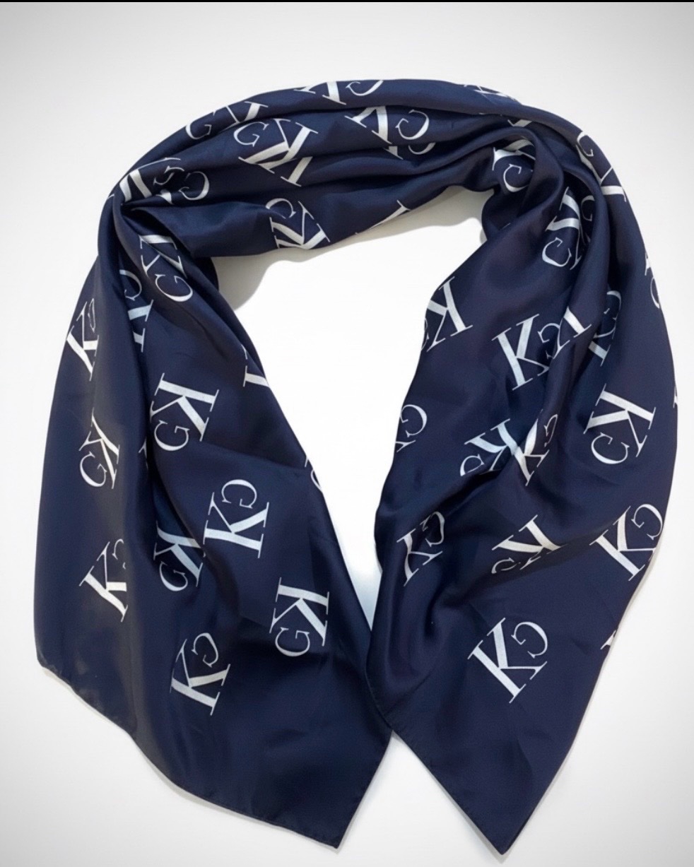 Un foulard  de la marque Calvin Klein, de couleur bleu marine avec un motif monogramme blanc