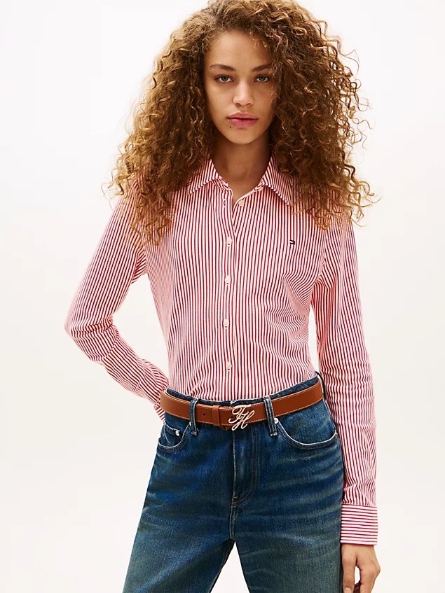 Cette chemise Tommy Hilfiger rouge et blanche présente un motif à rayures verticales et un logo drapeau brodé sur la poitrine