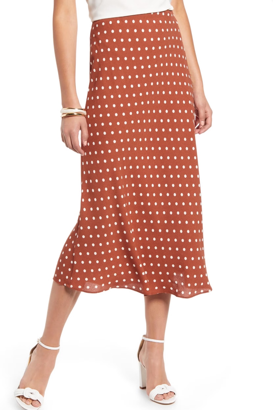 Jupe midi fluide en satin de couleur marron rouille avec un motif à pois blancs