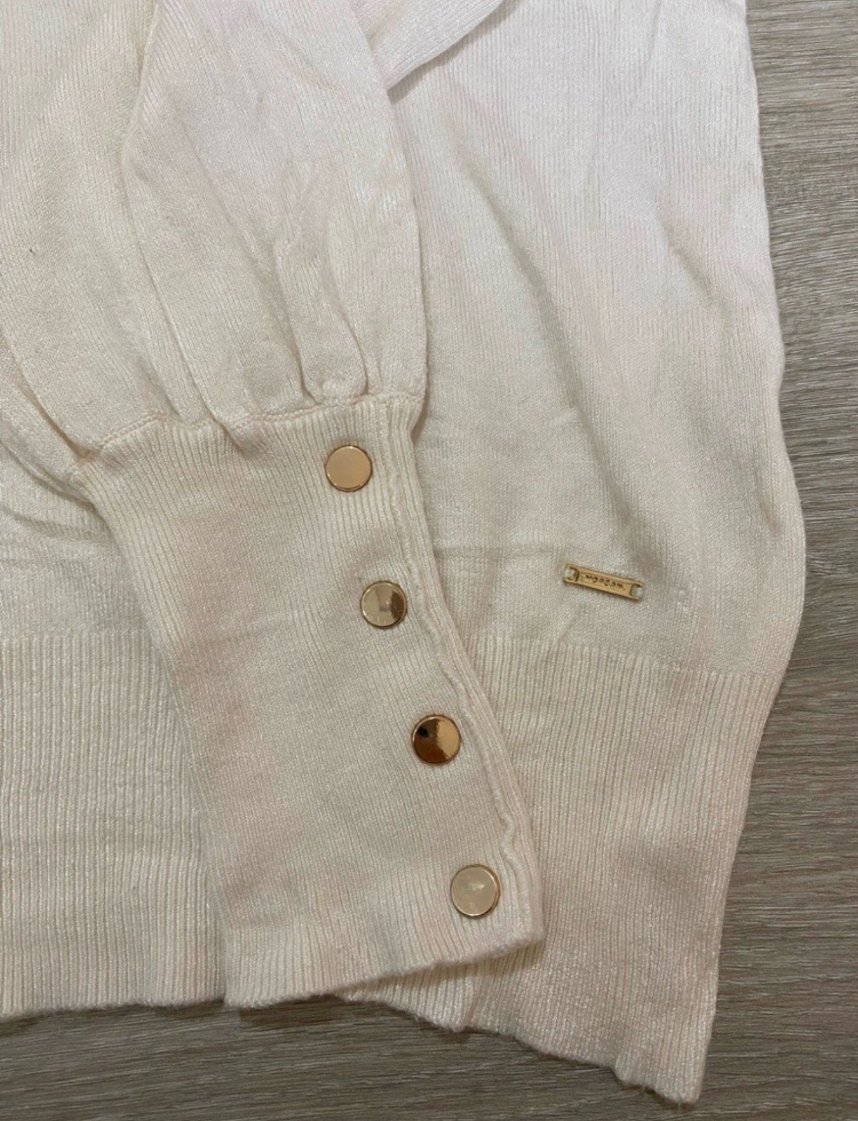 Pull à col V coupe ajustée, manches longues et poignets côtelés ornés de boutons dorés. Texture lisse pour une allure moderne et épurée taille (S/M)