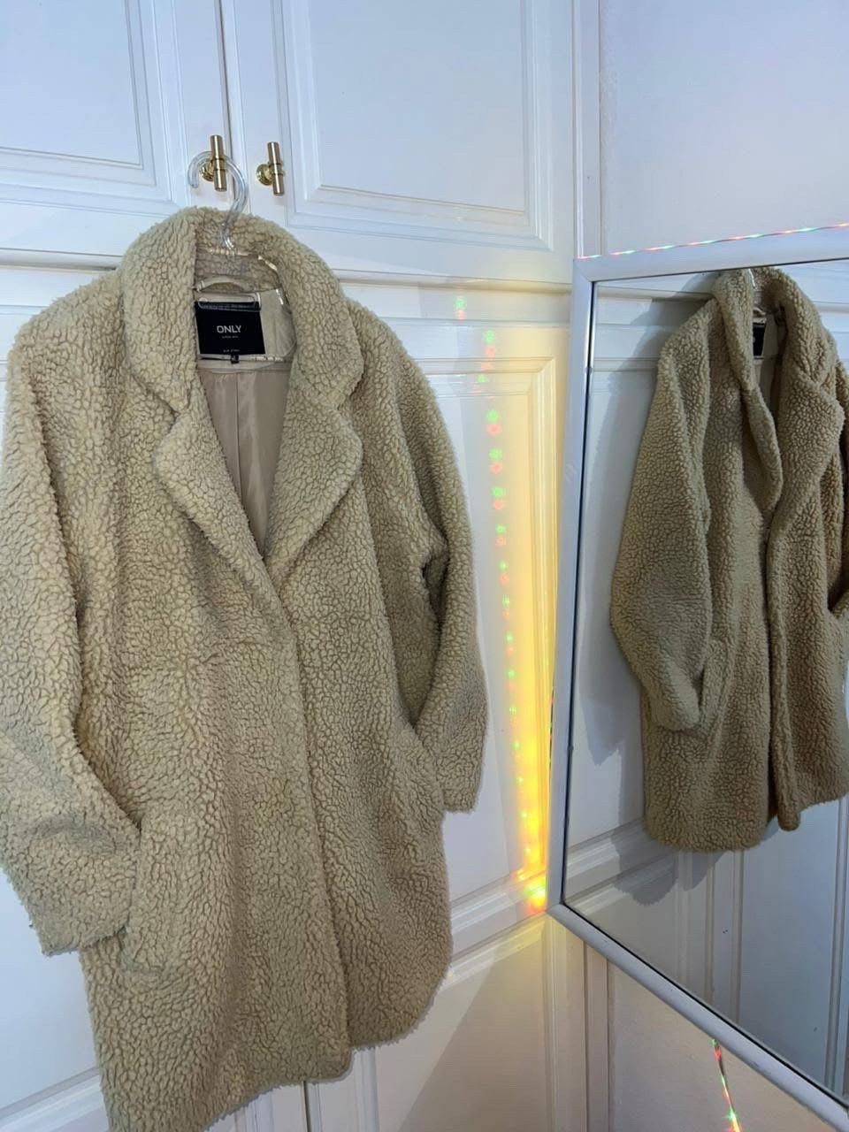 C'est un manteau long effet fourrure de couleur beige Neuf 