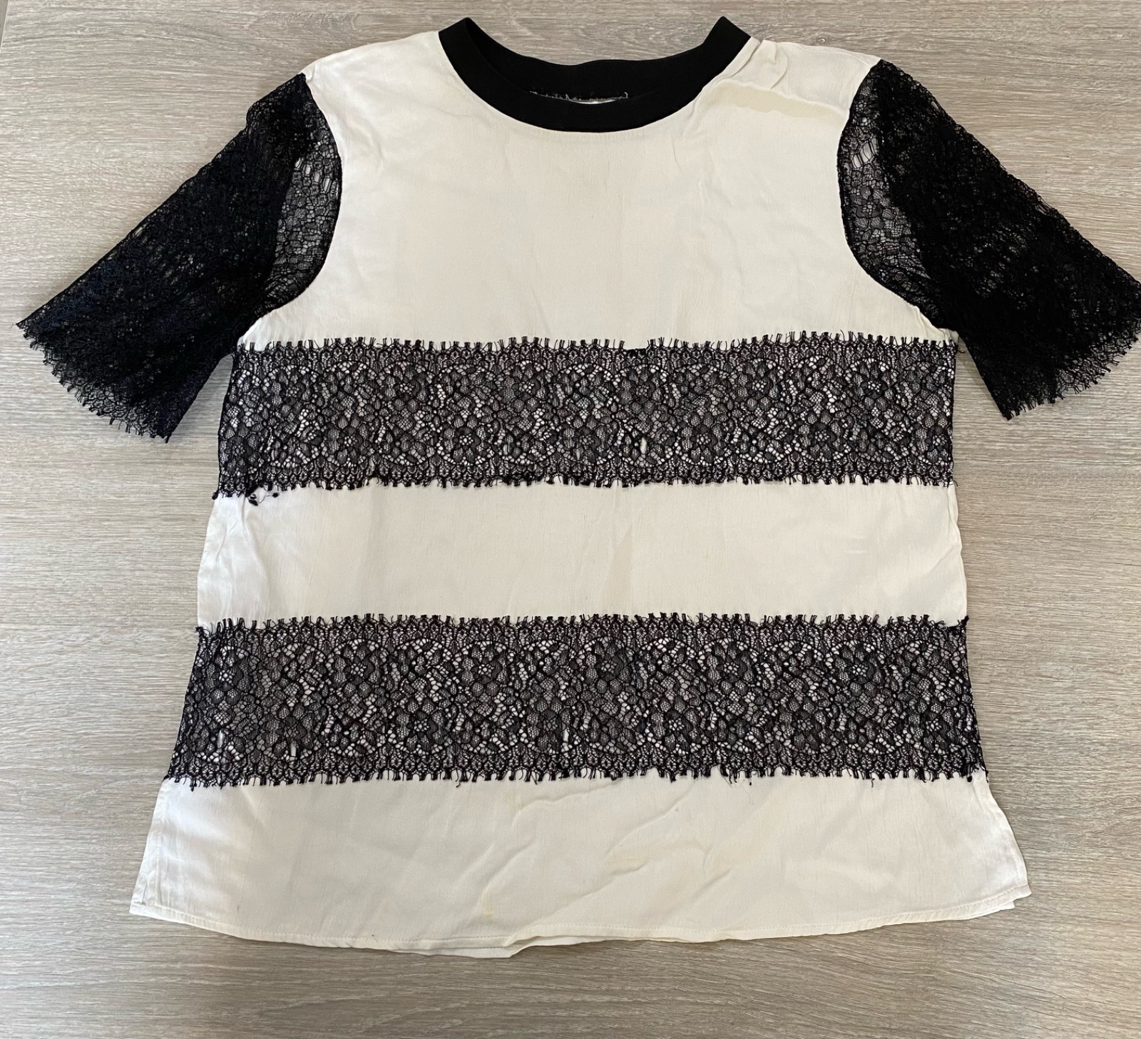  t-shirt combiné avec des détails en dentelle caractérisé par son col rond, ses manches courtes en dentelle et des bandes de dentelle contrastantes sur le corps du vêtement taille M