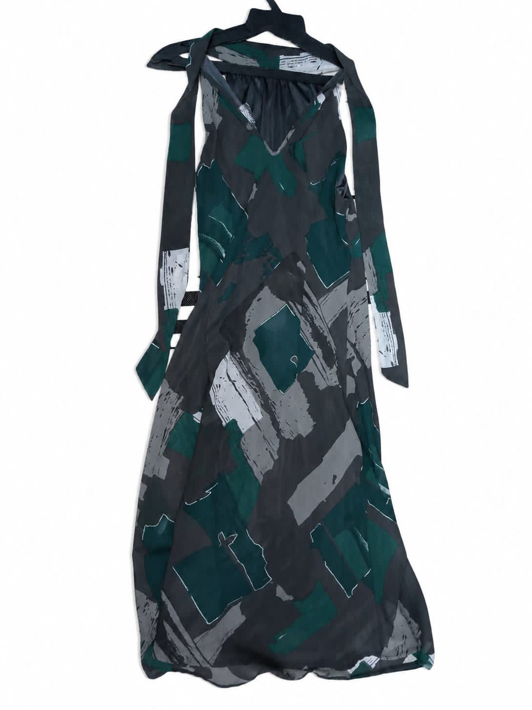 Robe élégante à motifs verts, gris et noirs avec ceinture.