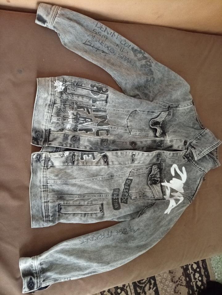 Veste en jean ZARA 🧥✨ Taille M, couleur gris foncé/noir délavé، coupe classique avec imprimés graphiques. Style vintage et décontracté, en bon état.