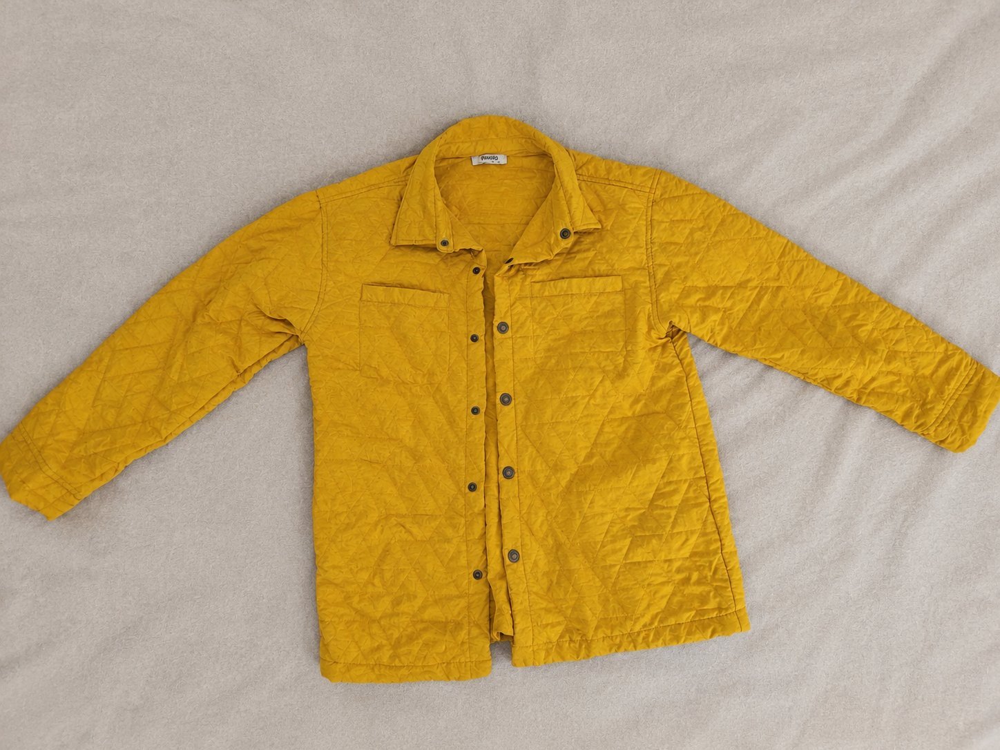 Veste matelassée jaune moutarde à capuche, fermeture à boutons-pression. Style décontracté, en bon état.