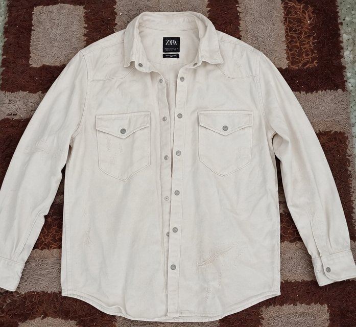 Veste en jean blanche Zara, coupe relaxed fit, avec poches à rabat et détails légèrement délavés. ✨