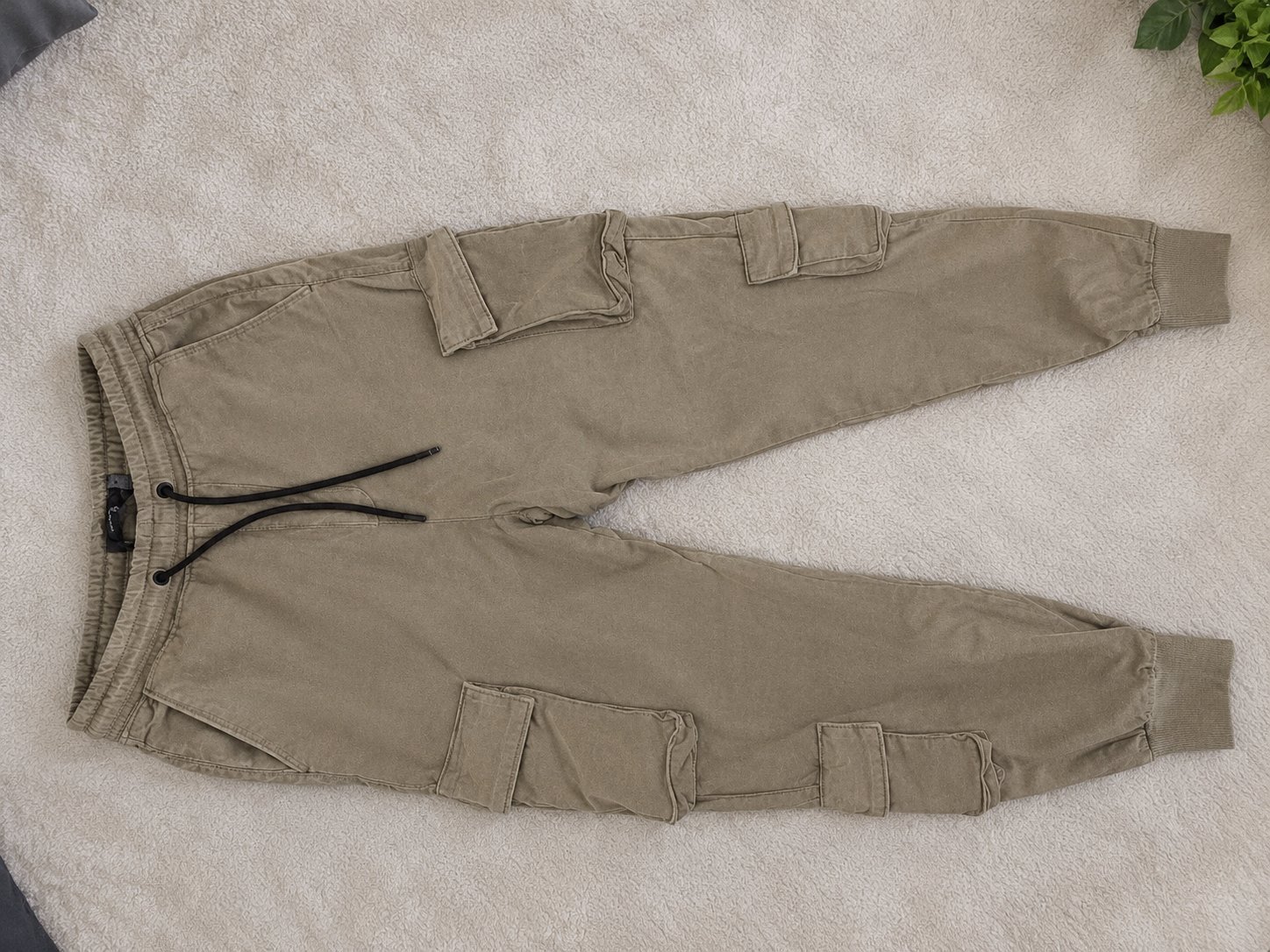 Pantalon cargo jogger beige kaki, avec poches latérales et taille élastique à cordon.