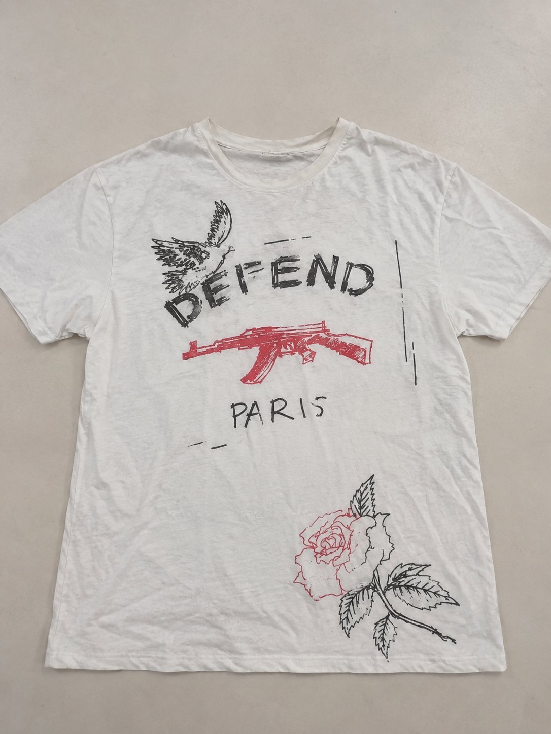 T-shirt blanc avec motif de colombes, inscription « PAIX » et « REVOLUTION », style streetwear.