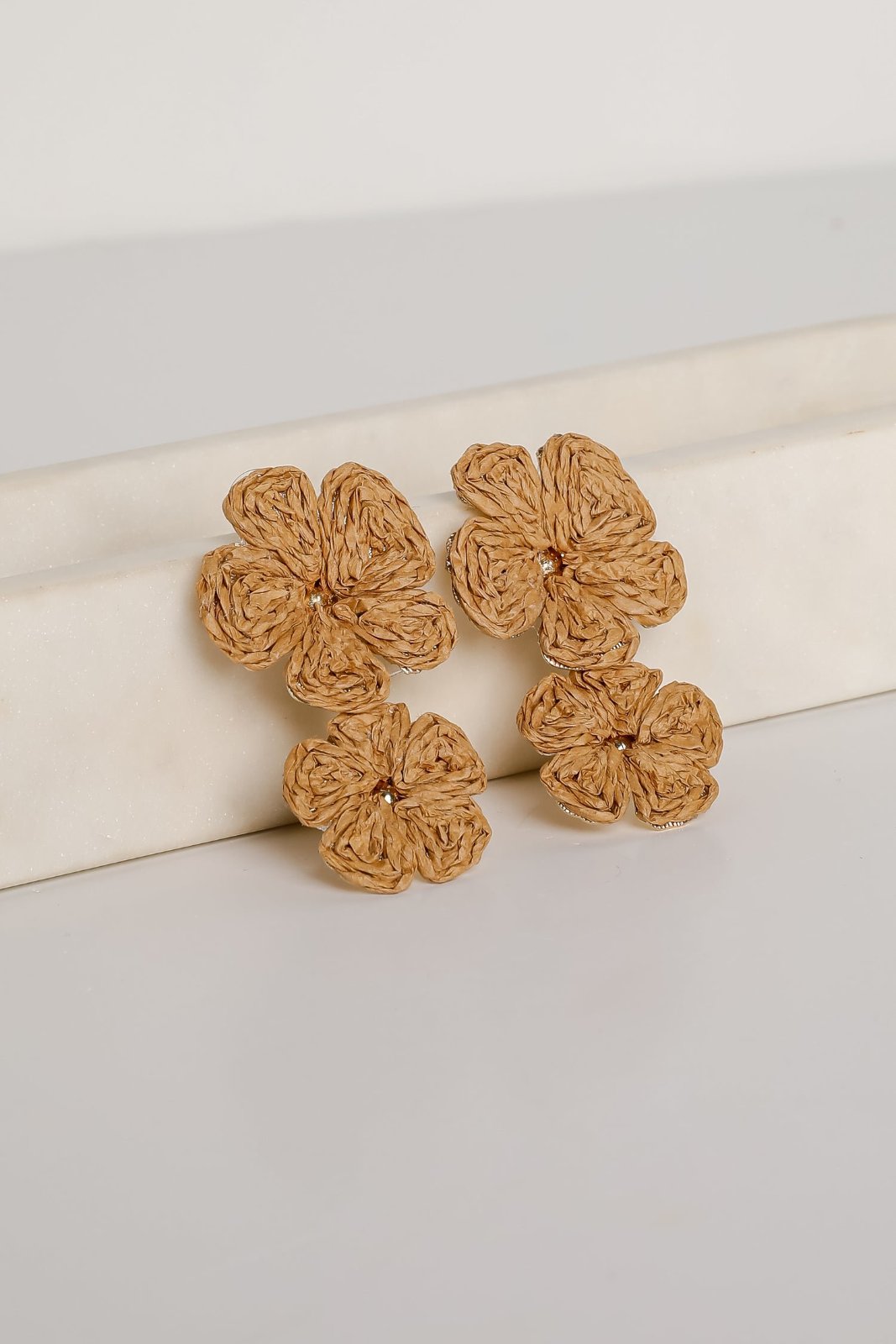 Boucles d'oreilles sont des bijoux fantaisie de style bohème en raphia tressé, représentant des fleurs