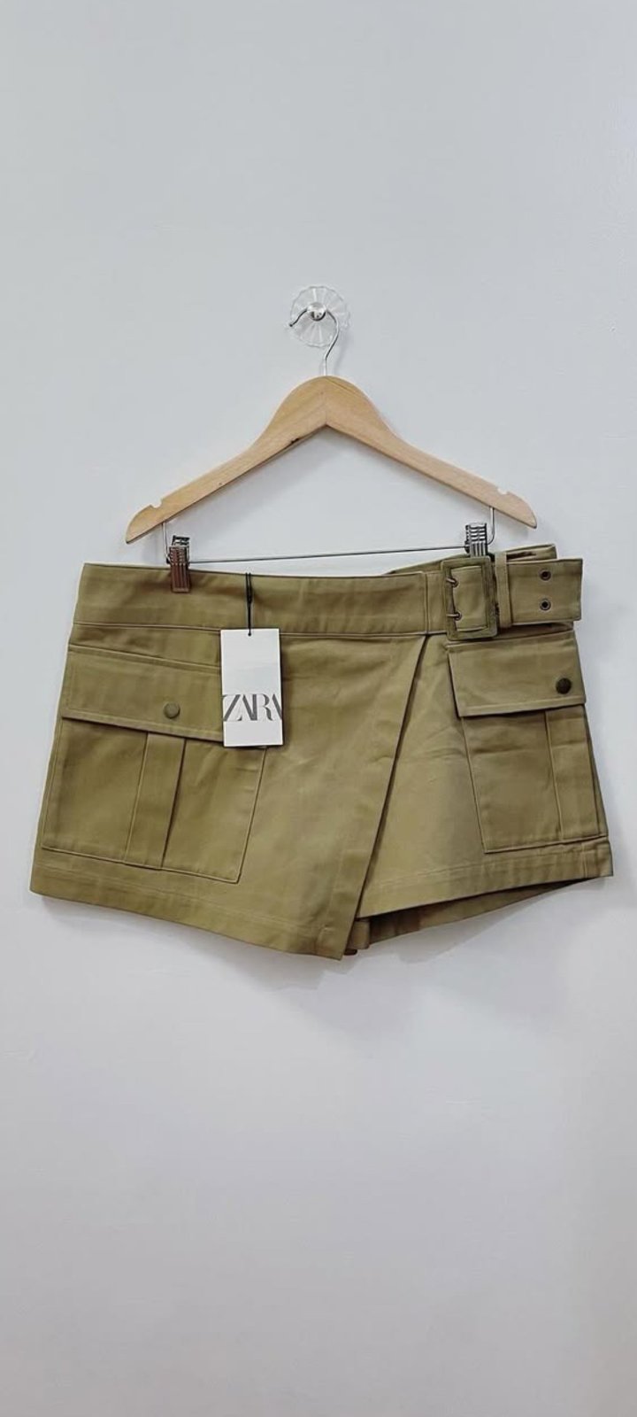 Short-jupe de style cargo de chez Zara est doté d'une ceinture ajustable avec une boucle, de poches latérales à rabat et d'un design portefeuille fih petit défaut  darba sghira barcha sans importance 