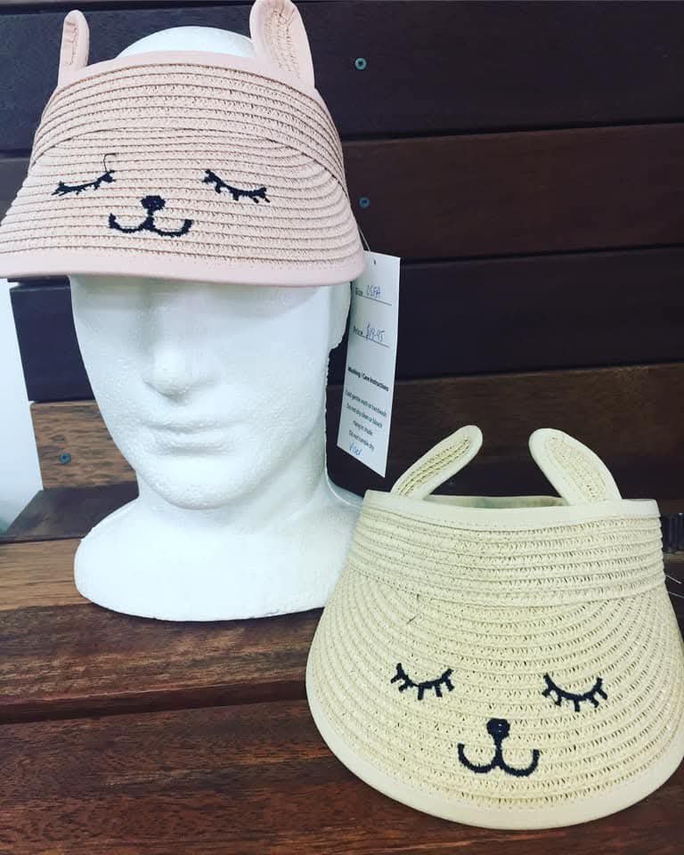  une visière de paille beige avec des oreilles et un visage brodé, probablement une visière pour enfant de marque générique.
