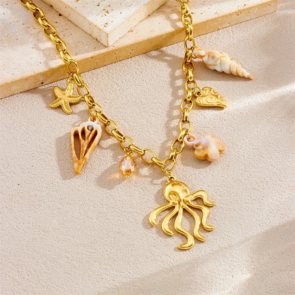 Collier fantaisie doré en acier inoxydable se distingue par ses pendentifs d'inspiration marine, notamment un poulpe imposant, une étoile de mer et des breloques coquillages