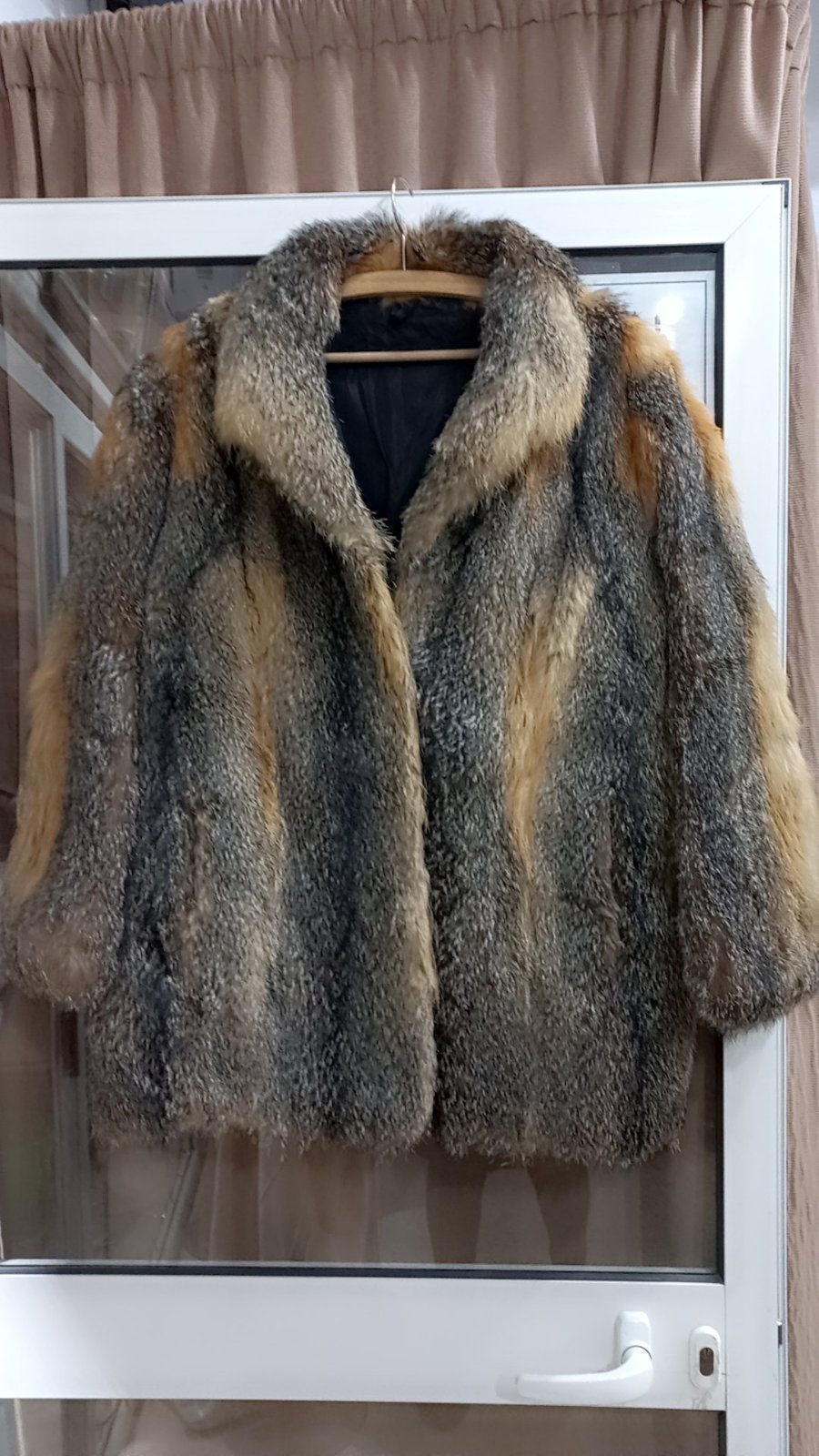 Un manteau de fourrure  de renard gris et beige vintage, probablement en fourrure de loup ou de coyote. 