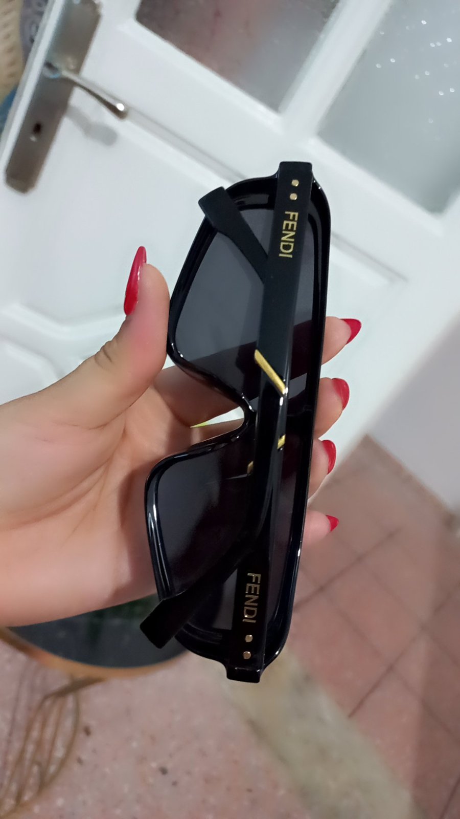 Paire de lunettes de soleil Fendi affiche une monture masque noire imposante et le logo de la marque visible sur le verre