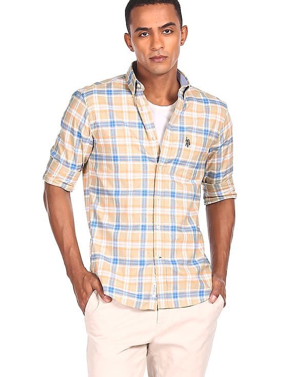 Une chemise à carreaux jaunes et bleus de la marque U.S. Polo Assn. qui se distingue par son motif lumineux et son petit logo brodé sur la poche poitrine.