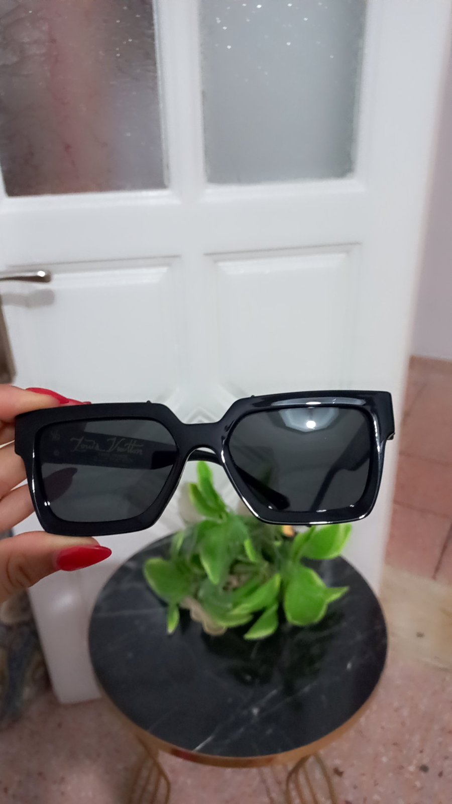 Lunettes de soleil Louis Vuitton se caractérisent par une monture carrée géométrique en acétate noir épais, rehaussée du logo discret de la maison gravé dans le coin supérieur du verre droit