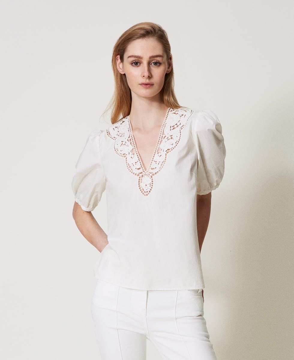 Pull blanc de style vintage avec des manches bouffantes et un col en dentelle.