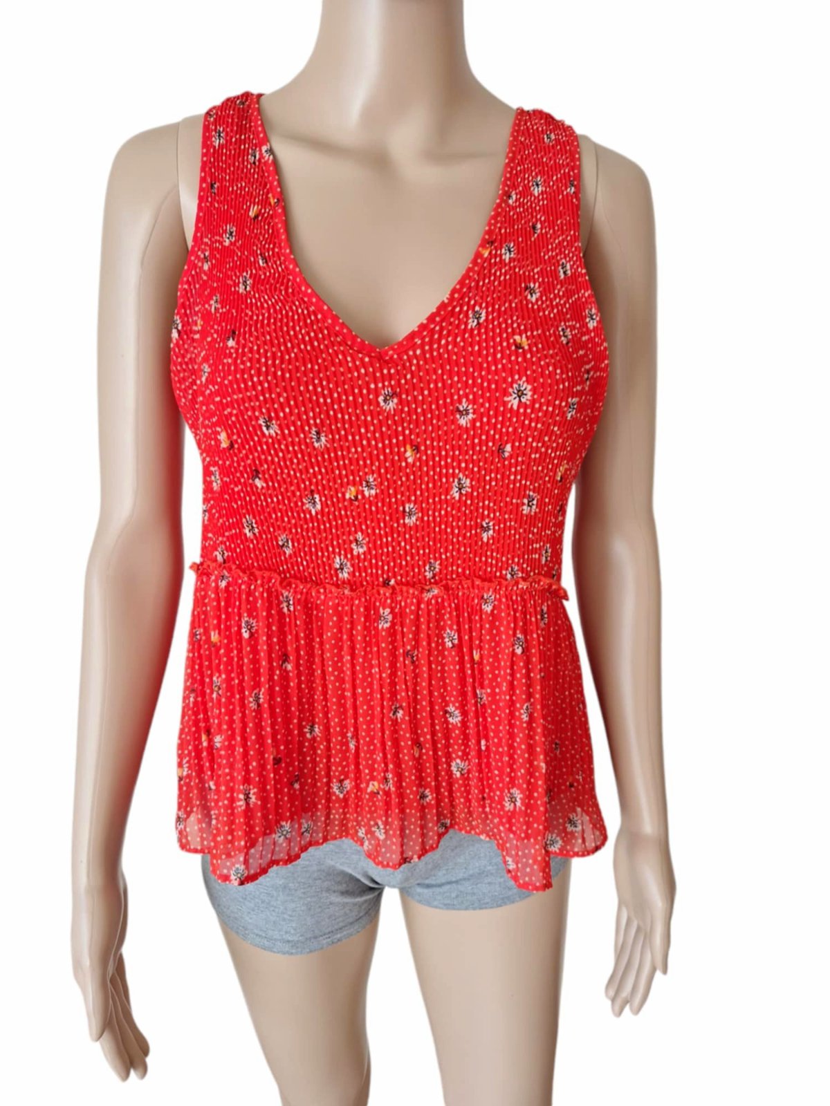 Chemisier rouge à fleurs Zara TRF présente une coupe péplum à volants et un détail noué dans le dos.   