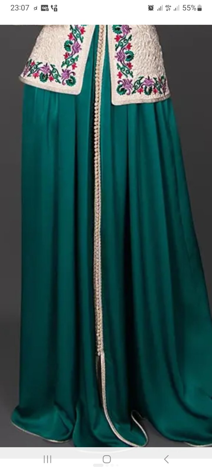 Robe traditionnelle élégante se compose d'une longue robe vert émeraude et d'un boléro blanc cassé orné de broderies dorées et de détails floraux.
