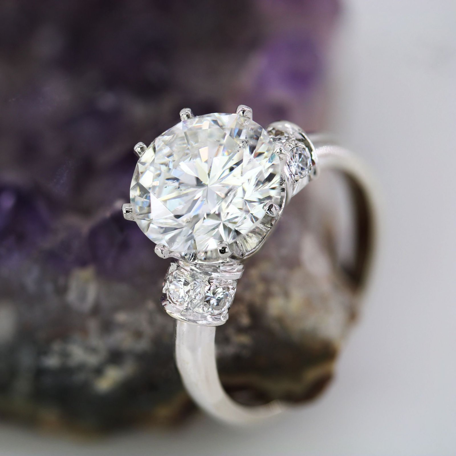 Bague de fiançailles est un solitaire en argent 925 orné d'un grand diamant central rond et deux petits diamants en côté taille 18  