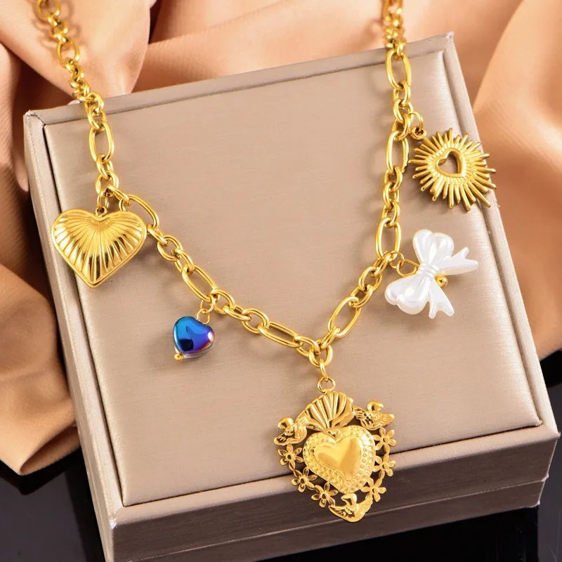 Collier "New Decorated World" en acier inoxydable doré arbore plusieurs pendentifs en forme de cœur, de soleil et de nœud