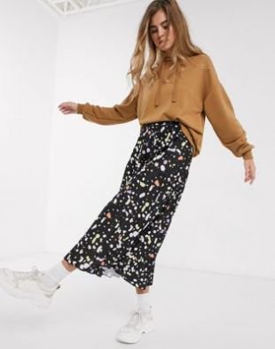 Jupe midi plissée ASOS Design arbore un motif tacheté coloré sur un fond noir