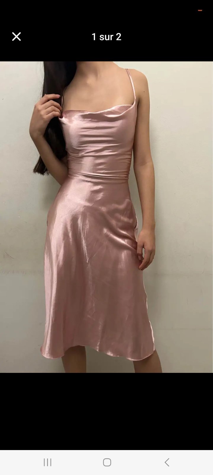  robe soiree mi-longue en satin rose de chez Boutique 1861 présente un col bénitier raffiné et des bretelles fines.