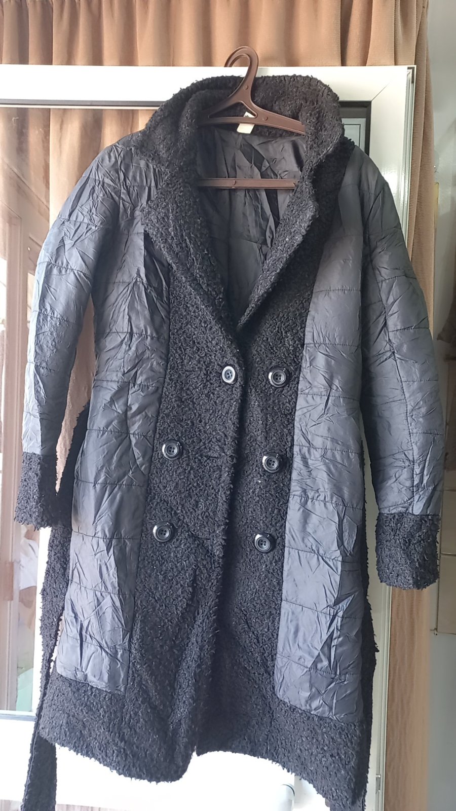  un manteau matelassé noir avec une doublure et des bordures en fausse fourrure. 