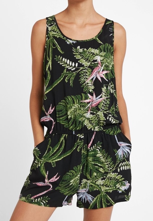 Combinaison sans manches est ornée d'un imprimé tropical vibrant sur fond noir, rappelant les styles hawaïens.