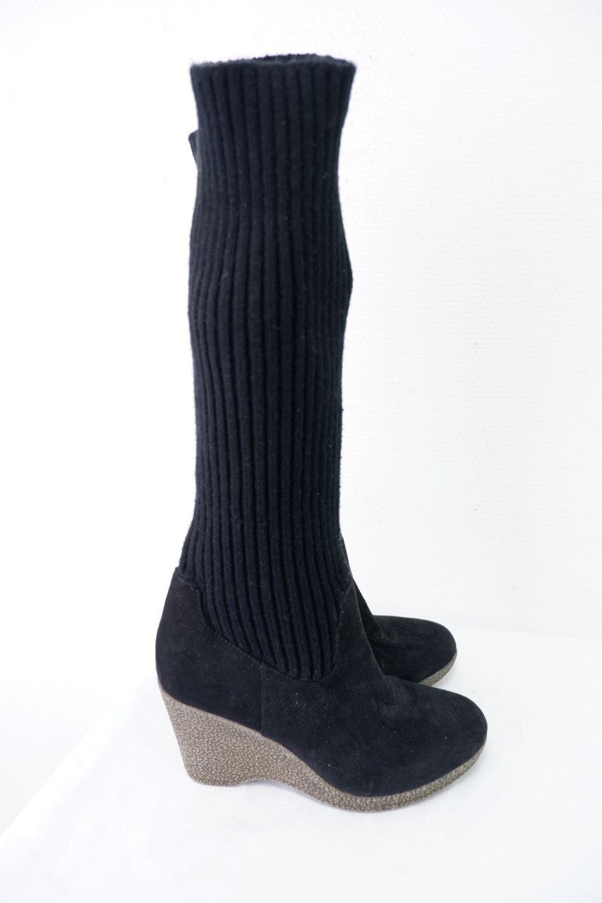 Une paire de bottes compensées noires en suède et tricot.
