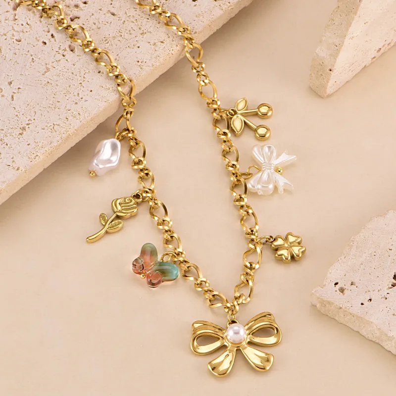 Collier en acier inoxydable NihaoJewelry présente plusieurs breloques dorées, notamment un nœud papillon, un papillon et une perle.