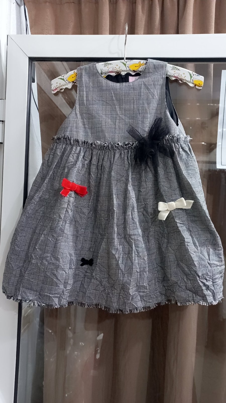 Robe à carreaux pour fille avec des nœuds décoratifs.