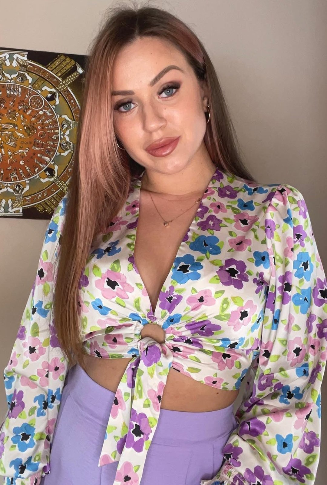 Blouse courte satinée de la marque Amisu est ornée d'un motif fleuri multicolore dans des tons violet, lilas, bleu ciel et rose pastel.