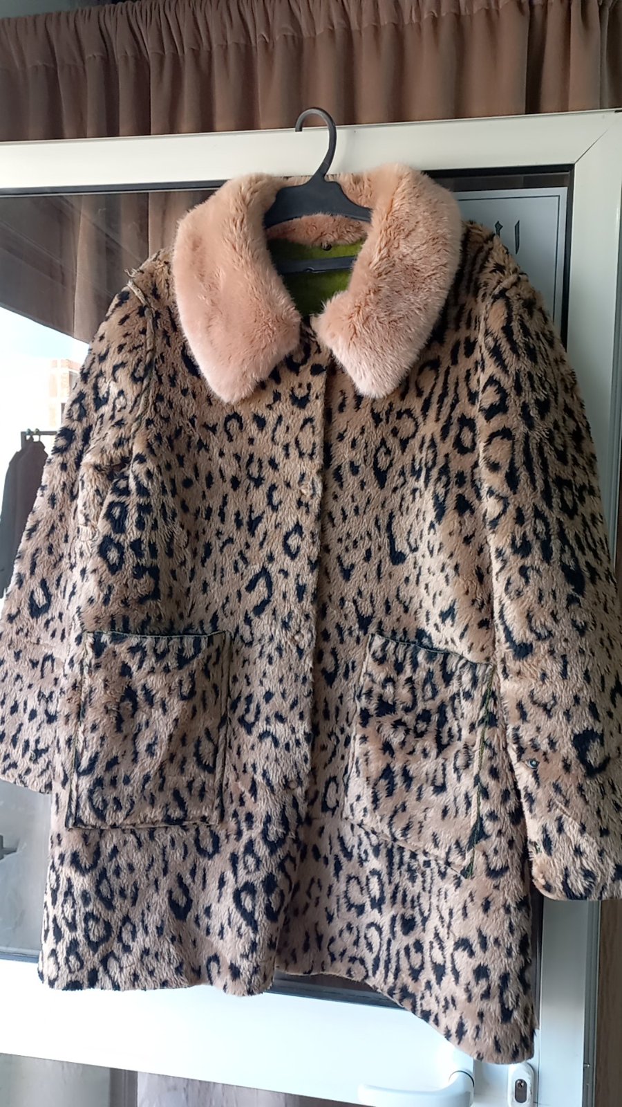 Un manteau en fausse fourrure à imprimé léopard double face habillé 