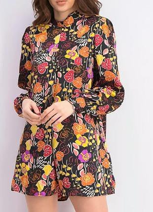 Combinaison mango à fond noir et imprimé floral coloré, caractérisée par un col montant et des manches longue fiha taftika sghira min tali tetgad facilement 