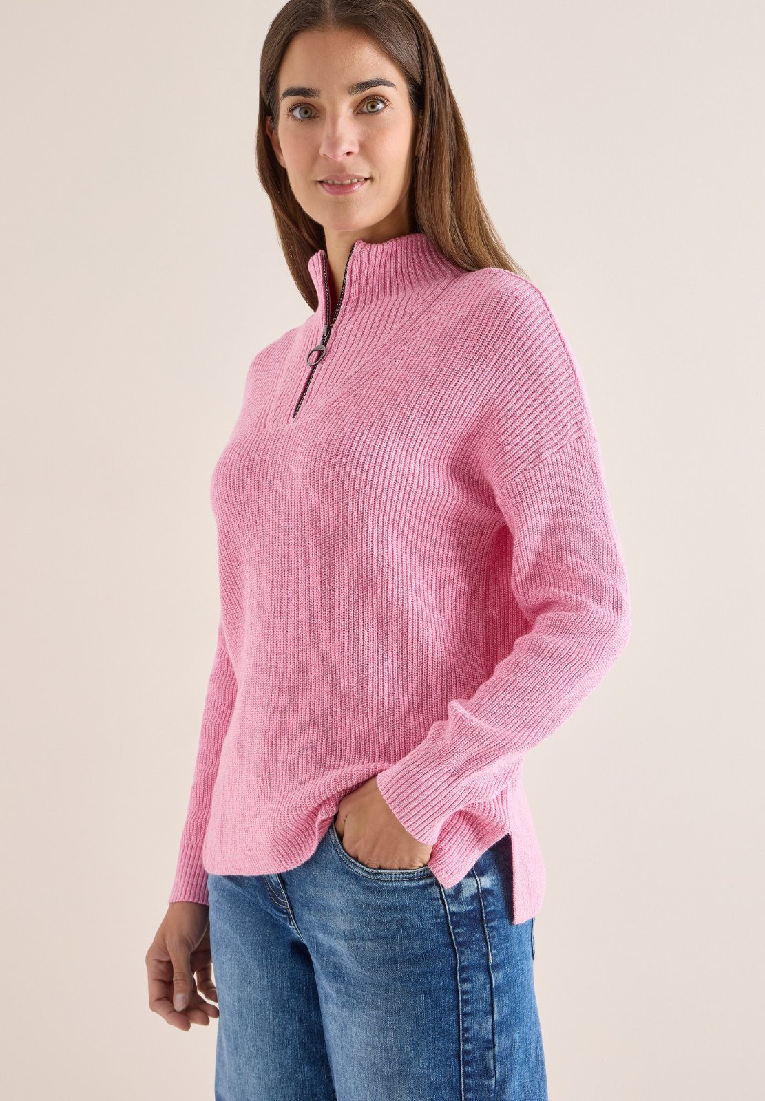 Un pull à capuche en maille rose de la marque Primark, doté d'un col zippé (type "camionneur").