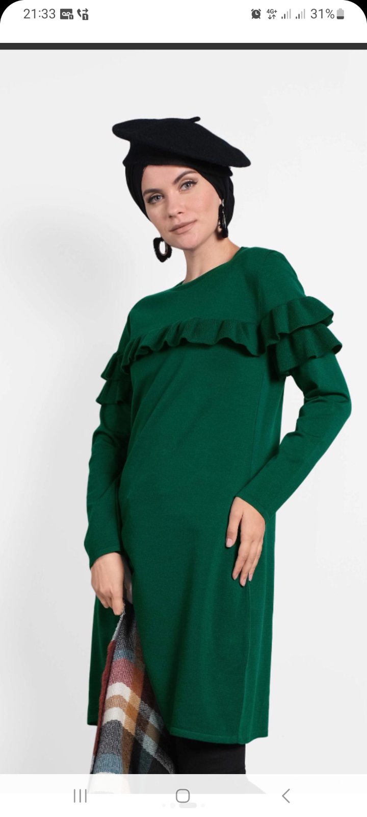 Robe verte foncée à manches longues et à col rond présente un élégant volant décoratif (ruffle) sur le haut de la poitrine.