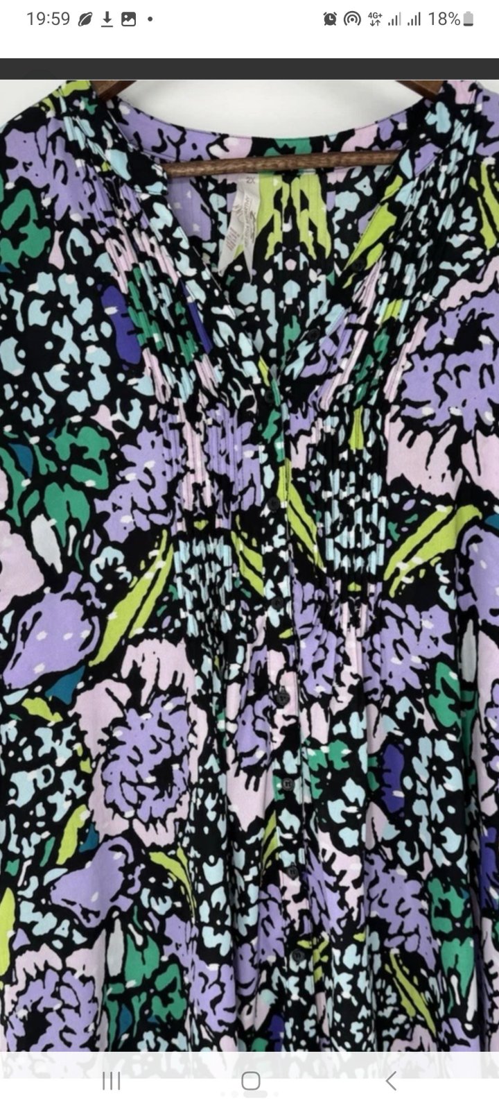 Chemisier noir à imprimé floral coloré présente des manches courtes à volants et un col rond.