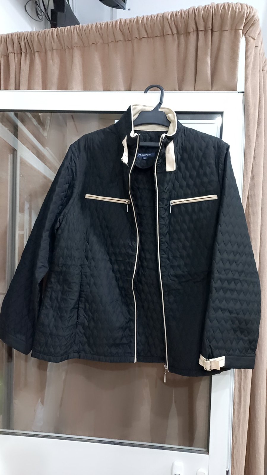 Une veste matelassée noire à fermeture éclair avec des accents beiges, probablement de la marque PARISPORT d'après l'étiquette intérieure neuf jamais porté 