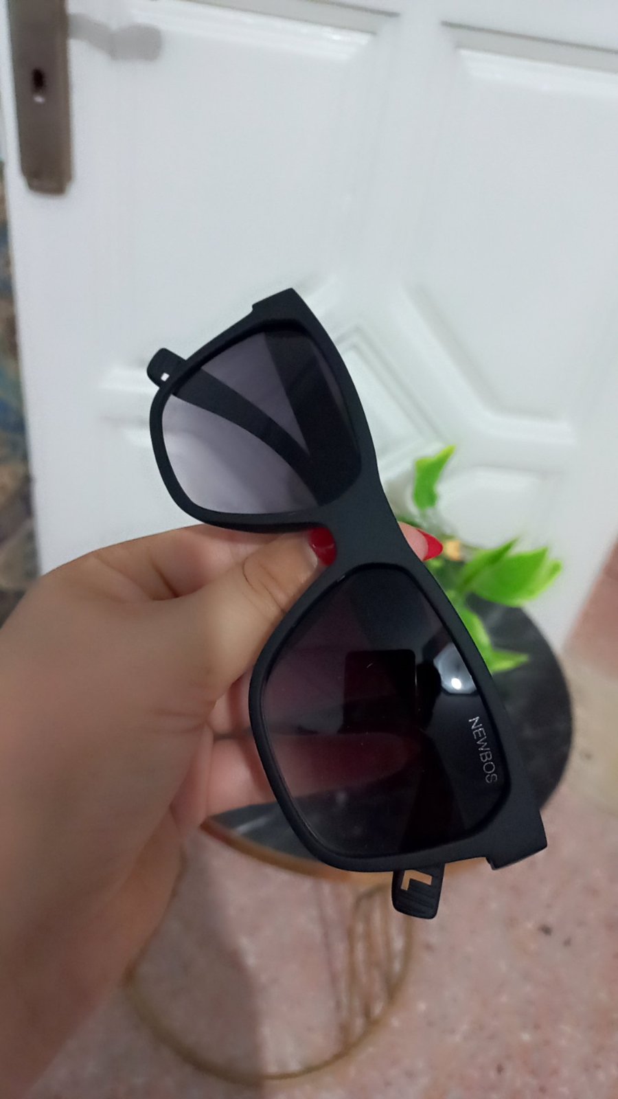 Lunettes de soleil de la marque NEWBOS arborent une monture carrée en acétate noir mat associée à des verres fumés dégradés.