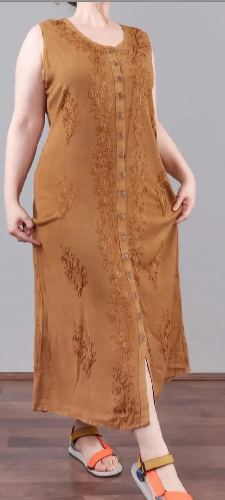Robe longue ocre, de style indien, est ornée de broderies dorées et se distingue par ses boutons sur toute la longueur.