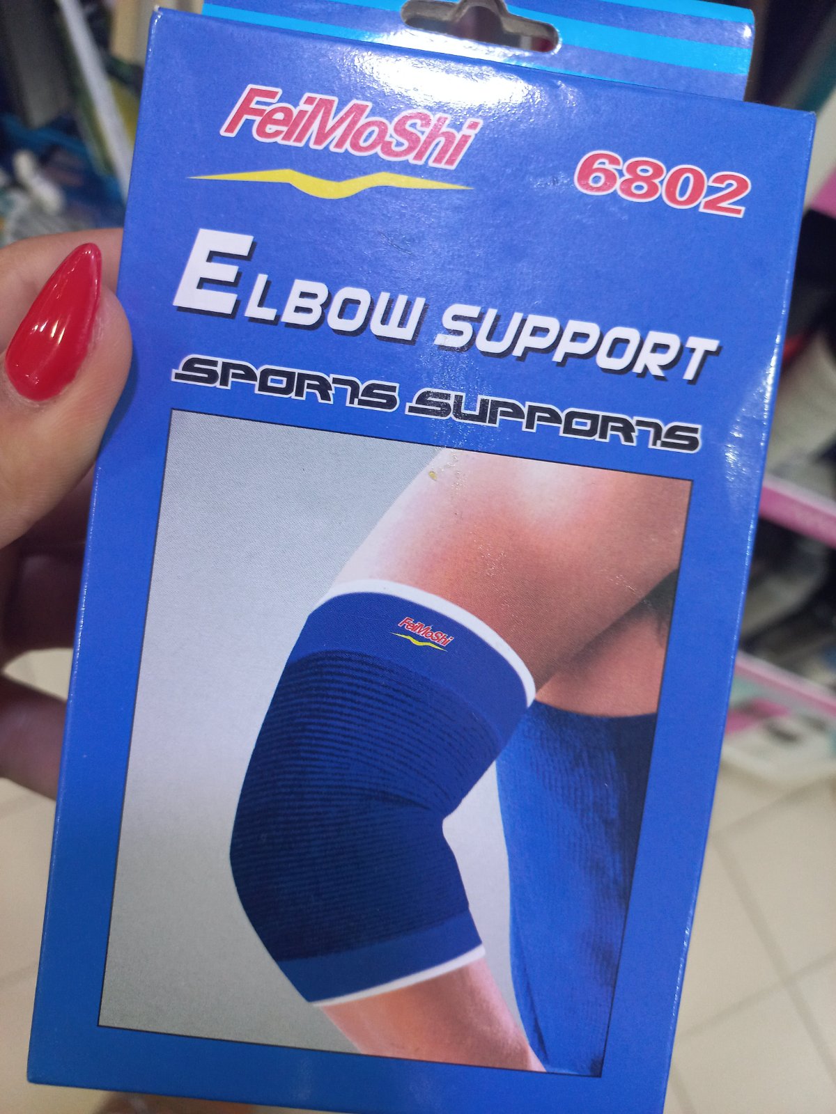 Une coudière de maintien élastique FeiMoShi 6802, conçue pour apporter une compression légère et stabiliser l'articulation lors des activités sportives.
