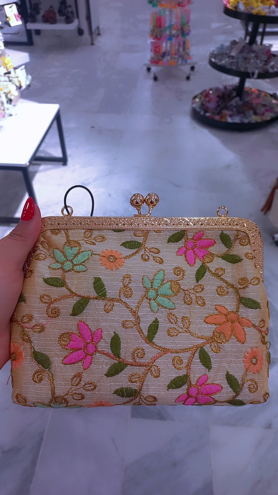 Pochette de soirée crème présente une broderie florale multicolore vibrante et un fermoir métallique doré