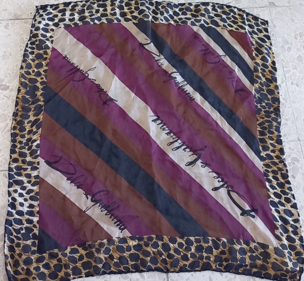 Un foulard en soie de la marque Dolce & Gabbana avec un motif léopard et des rayures diagonales. 